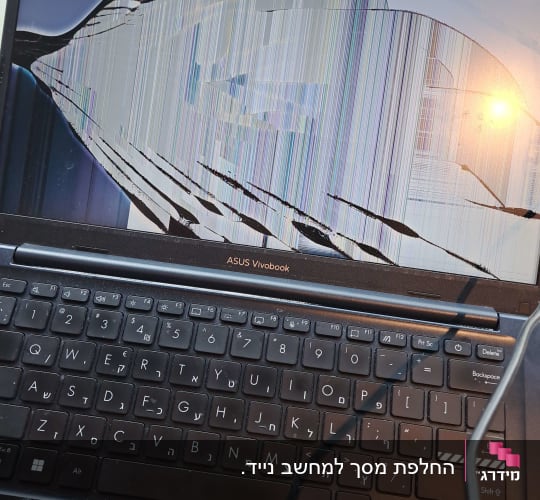 מחשב נייד עם מסך שבור ומקלדת בעברית